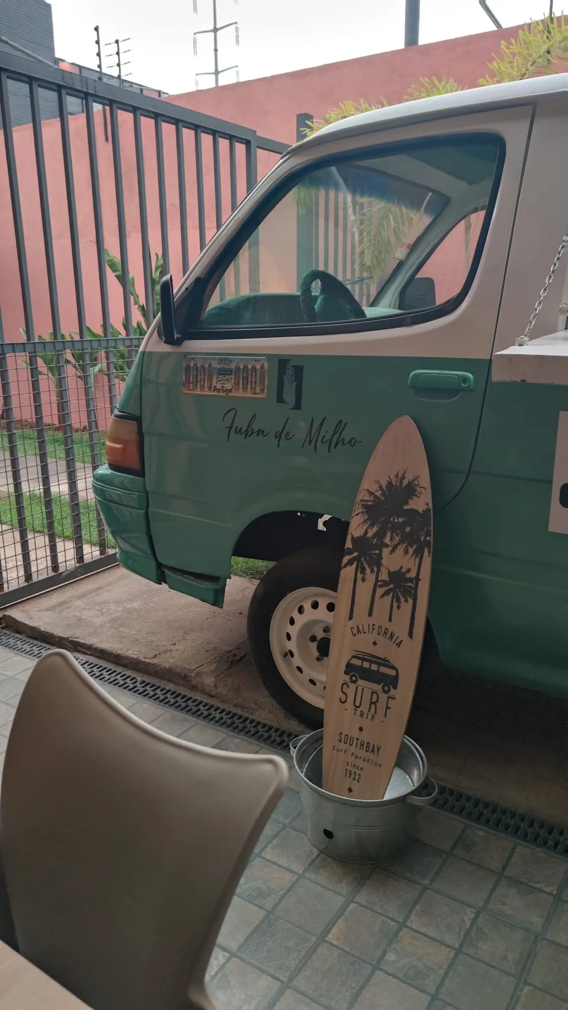 Carrinha VW verde com uma prancha de surf Fuba de Milho no pátio