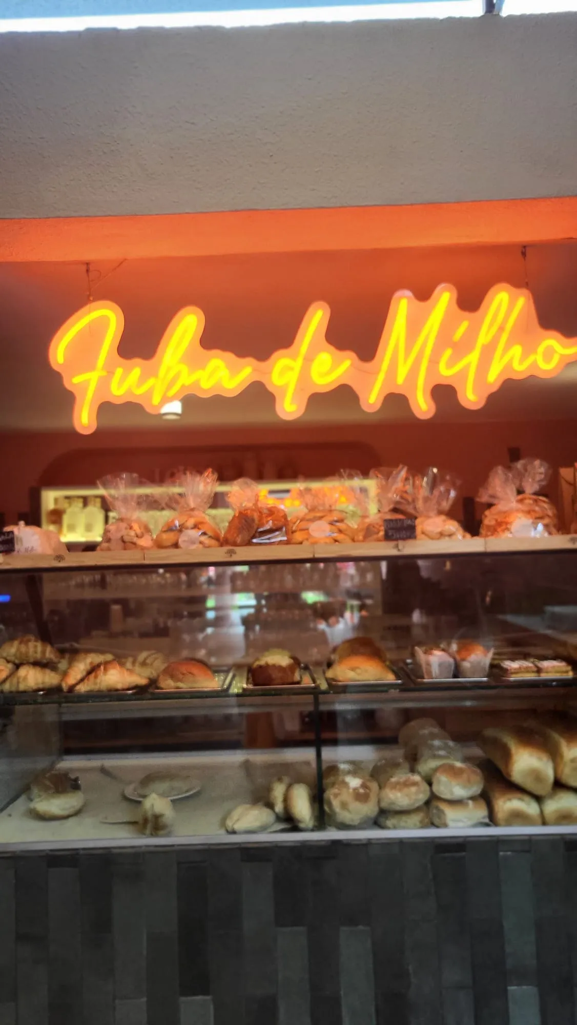 Néon Fuba de Milho por cima da vitrine com pão e pastelaria