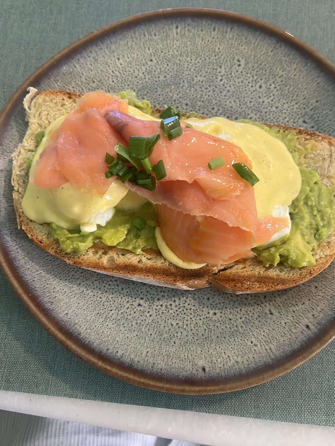 Ovo benedict com salmão fumado e abacate sobre pão torrado
