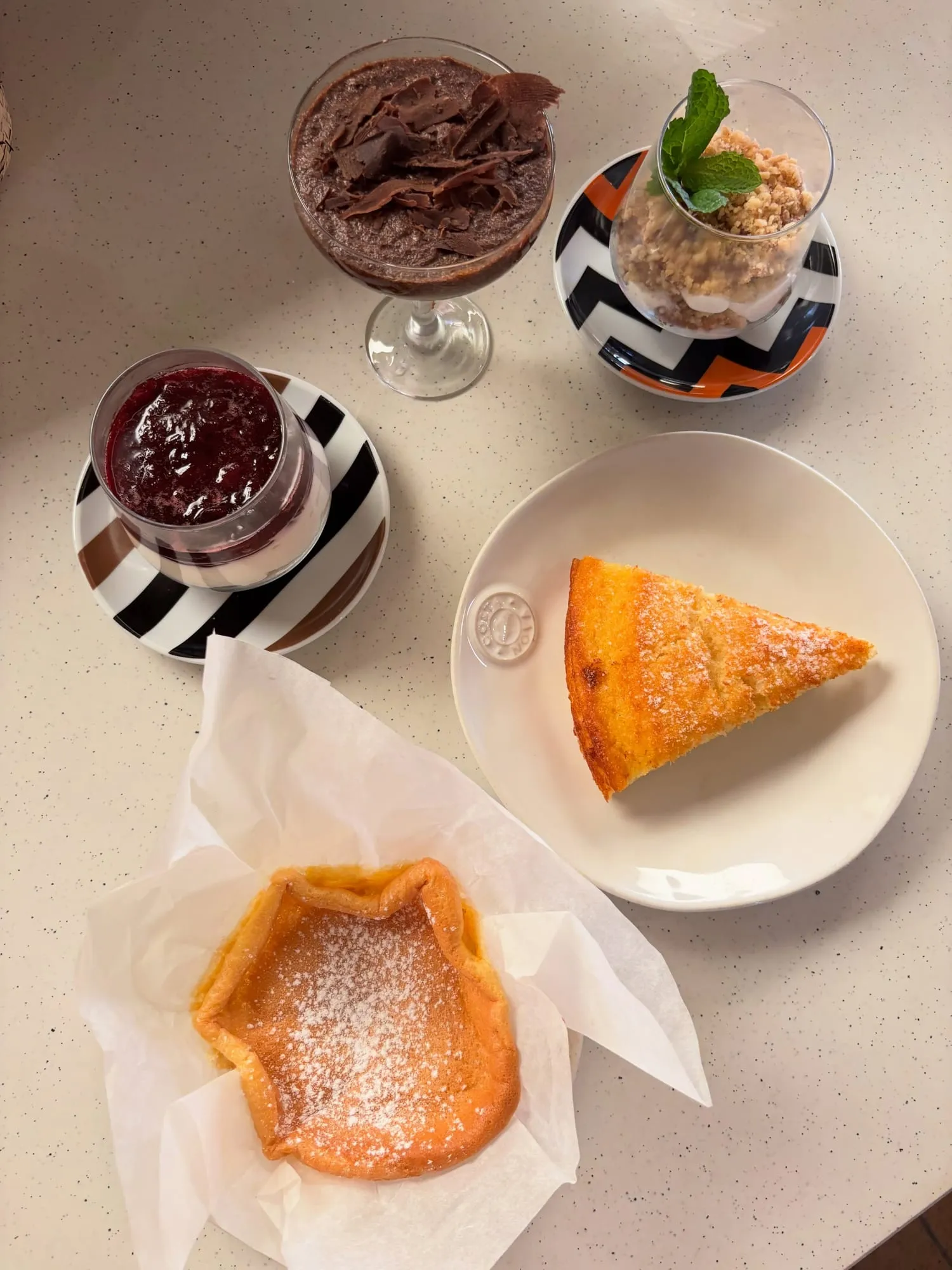 Fatia de bolo de fuba de milho, mousse de chocolate, cheesecake de frutos vermelhos e crumble de maçã